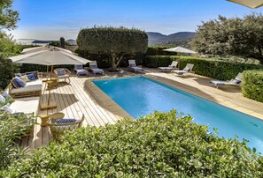 Una piscina al aire libre, tumbonas