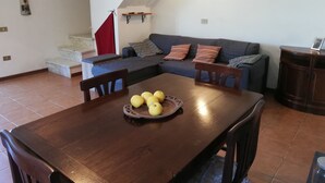 A living room with a dining table, a sofa, and a staircase. - Intimate little paradise! (Camaiore)