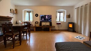 A cozy living room with a dining area, a fireplace, and a television. - Intimate little paradise! (Camaiore)