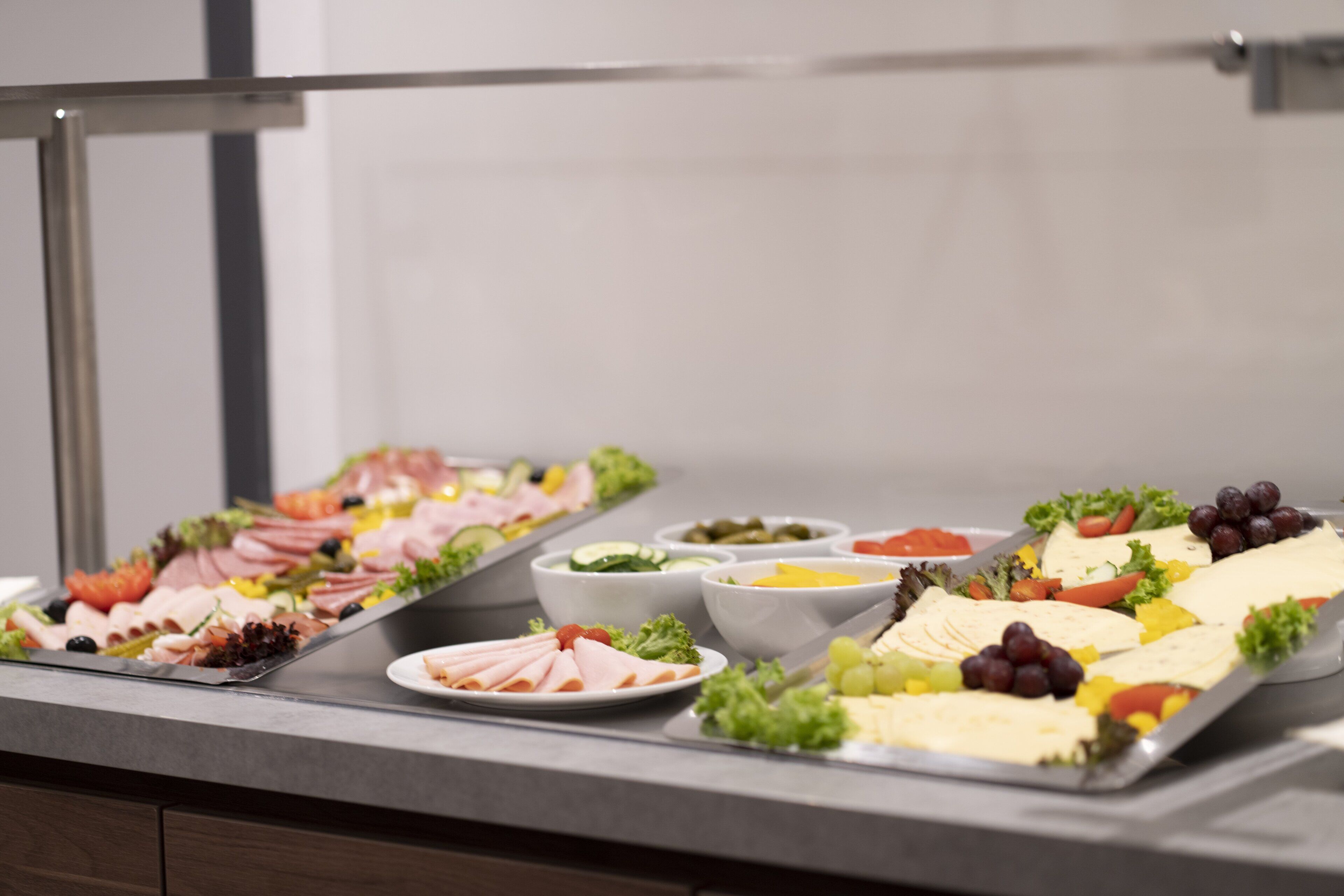 A buffet with various food items including meats, cheeses, and vegetables.