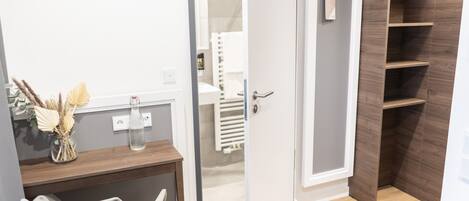A bathroom with a wooden vanity, a towel rack, and a shower area.