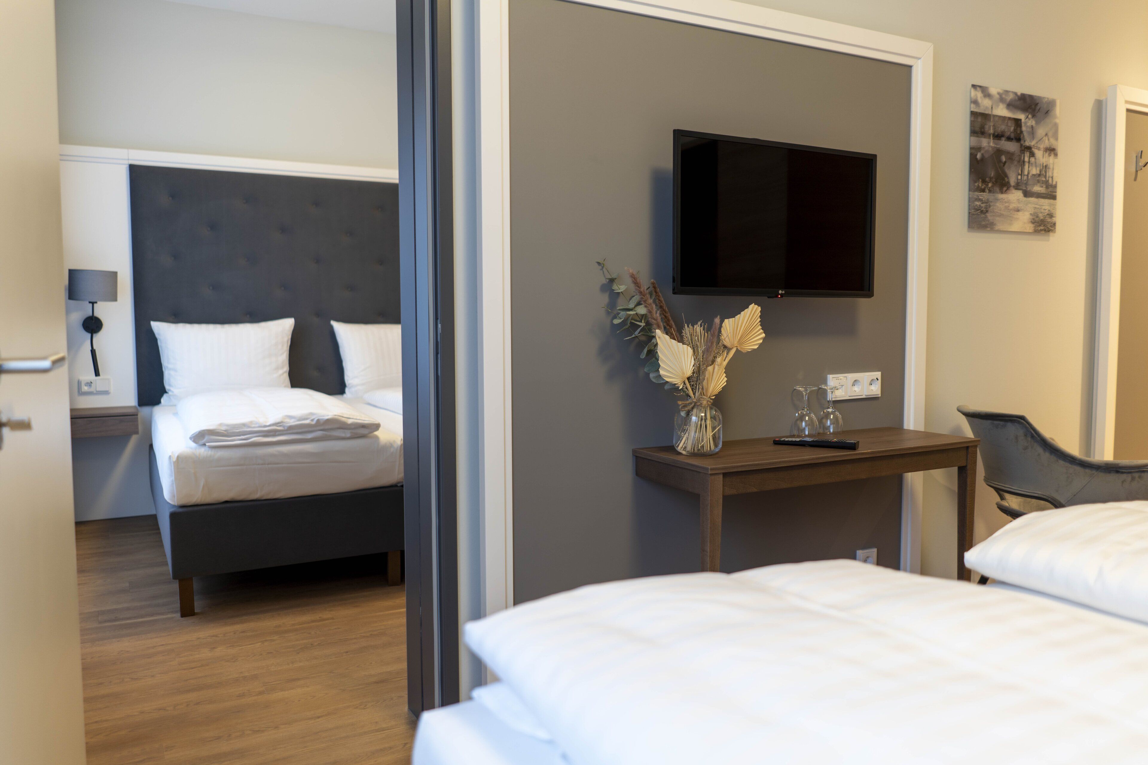 Habitación de hotel con cama, escritorio con televisor y una silla.