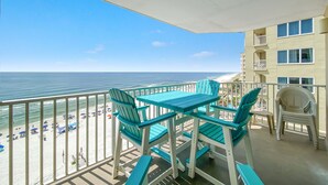 A balcony with a view of the beach and ocean.