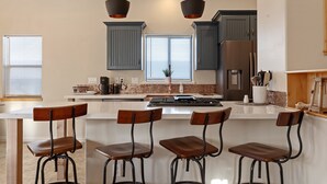 A modern kitchen with a central island, bar stools, and a large refrigerator. - Large Private Home in Jerome, AZ w/ Full Kitchen (Jerome)