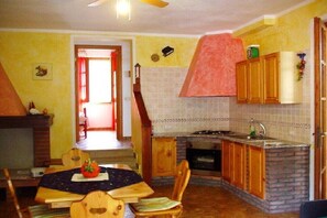 A compact kitchen with a brick backsplash, wooden cabinets, and a small island.