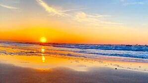 A beach at sunset with the sun reflecting on the wet sand. - Winds of Change - Easy Beach Access (Bolivar Peninsula)