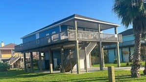 A two-story building with a balcony and a staircase leading to the upper floor. - Winds of Change - Easy Beach Access (Bolivar Peninsula)