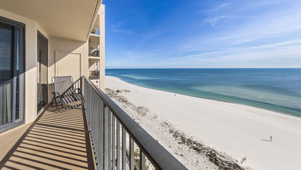 Un balcon avec vue sur une plage et l’océan.