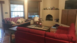Ein Wohnzimmer mit roten Sofas, einem Kamin und einem Fernseher.
