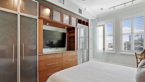 A bedroom with a large bed, built-in wardrobe, and a TV. - Heart of downtown (St. Petersburg)
