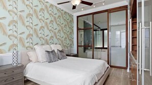 A bedroom with a bed, nightstands, a ceiling fan, and a sliding glass door leading to a balcony. - Heart of downtown (St. Petersburg)