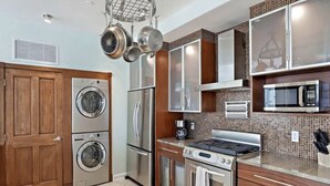 A compact kitchen with a washing machine, a refrigerator, a stove, and a microwave. - Heart of downtown (St. Petersburg)