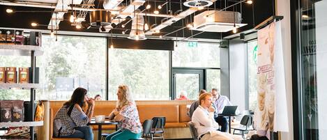 A Starbucks with seating areas, large windows, and a modern interior design.