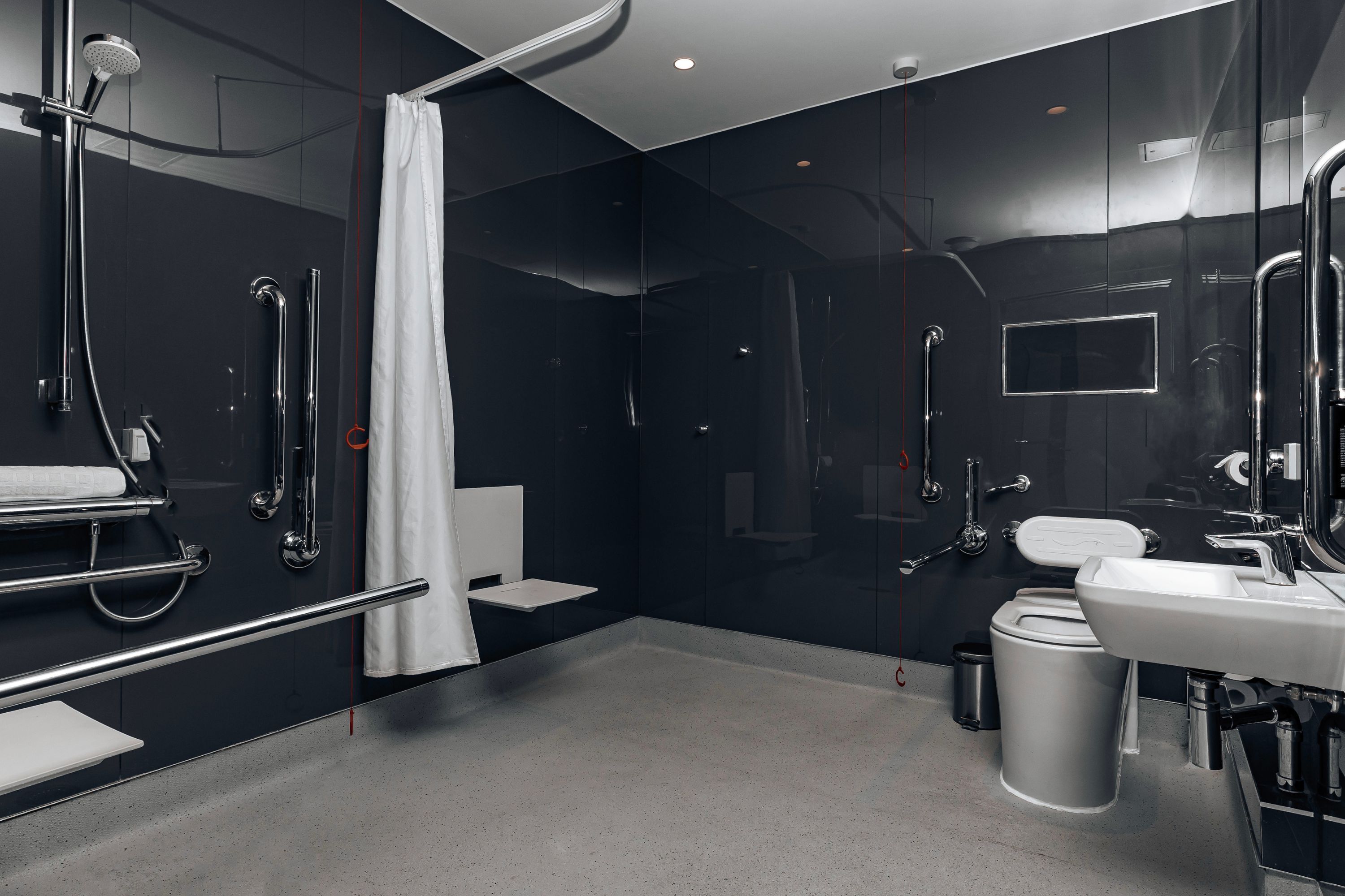 A modern bathroom with a shower, toilet, and sink.