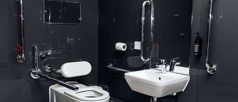 Un baño moderno con inodoro, bidé, lavamanos y secamanos.