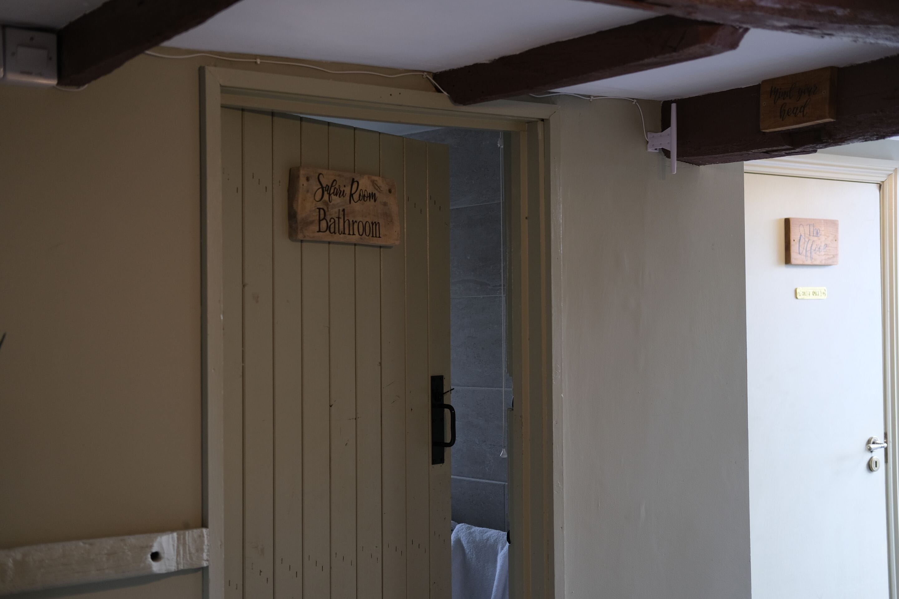 A bathroom with a wooden door labeled "Safari Room Bathroom."