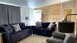 A cozy living room with two dark sofas, a wooden coffee table, and a lamp. - Sunrise, Sunset, Relax, Repeat Lamoka Cove (Bradford)