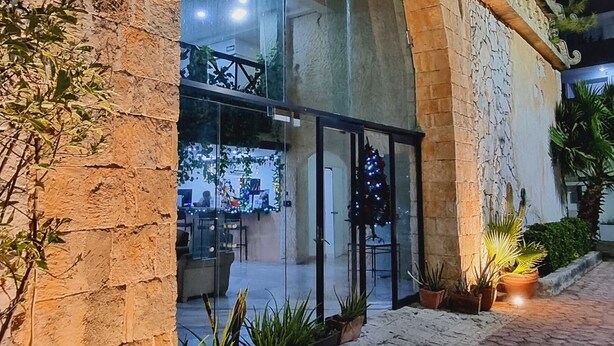 A building with a glass entrance, stone pillars, and a paved walkway. - Essenzia de Cancun (Cancun)