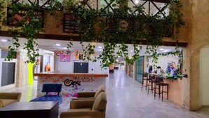 A reception area with a counter, chairs, and a seating area with a sofa and a table. - Essenzia de Cancun (Cancun)
