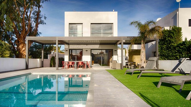 A modern house with a swimming pool, outdoor seating, and a covered patio. - TER MARAVILLOSA VILLA CANAL TER,PISCINA,WIFI, PARKING (Empuriabrava)