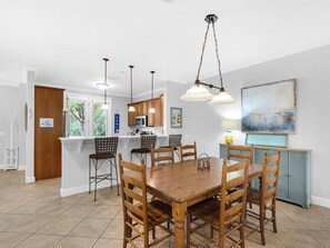 A modern kitchen with white cabinets, a central island, and pendant lighting.