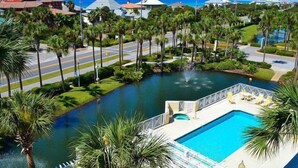 A resort with a swimming pool, palm trees, and a view of the ocean. - Spacious two bedroom, 2 1/2 bath townhome with sleeping loft (Santa Rosa Beach)