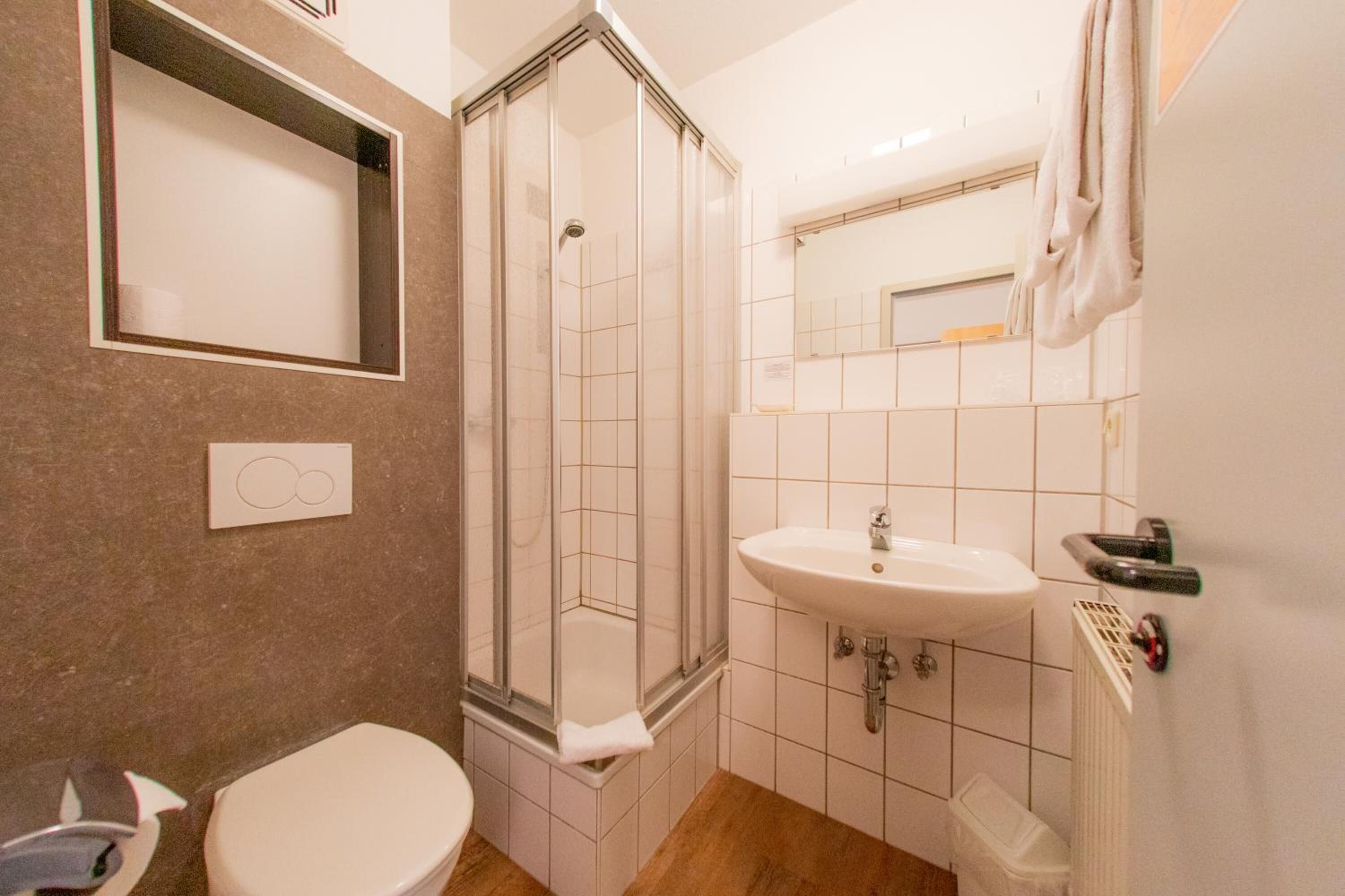Un baño con inodoro, ducha y lavamanos.