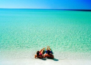 Una pareja descansando en una playa con aguas turquesas cristalinas.
