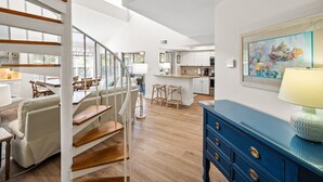 Un salón amplio con una escalera, un comedor y una cocina.