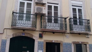 A multi-story building with balconies, air conditioning units, and a tiled entrance.