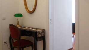 A room with a desk, chair, and a mirror on the wall.