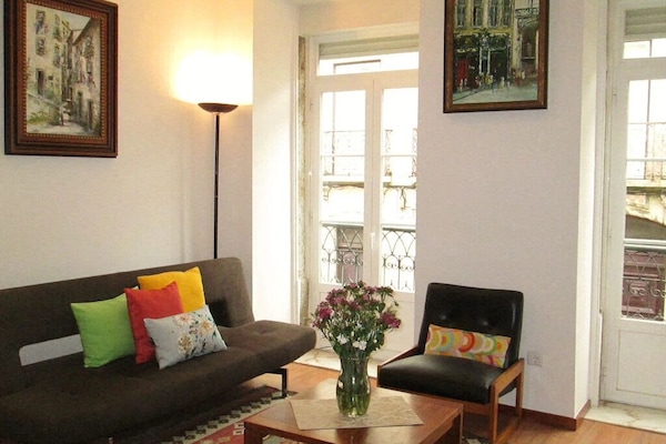 Salon très lumineux avec deux grandes fenêtres.