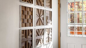 A wall with multiple wooden panels arranged in a grid pattern. - Cozy Cabin w Lake, Hot Tub, Huge Deck & Fire Pit (Mathias)
