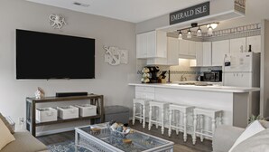 Een moderne woonkamer met een flatscreen televisie, een salontafel en een bank.