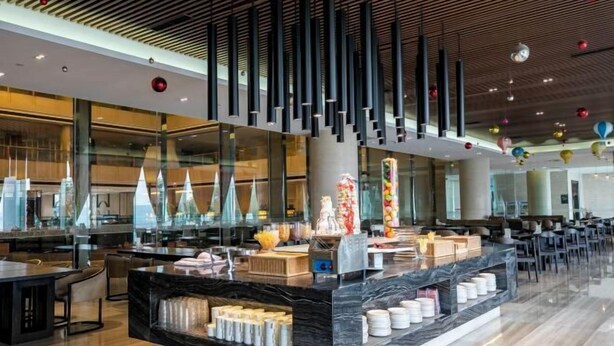 A modern hotel lobby with a marble reception desk, glass partitions, and a ceiling with vertical light fixtures. - Rosedale Chunshenhu Resort Hotel Suzhou (Suzhou)