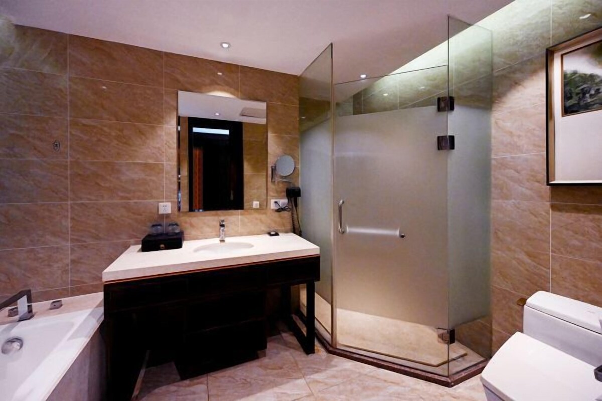 A modern bathroom with a glass-enclosed shower, a double sink vanity, and a toilet.