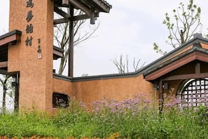A building with a brick facade, a large vertical sign, and a gate. - Rosedale Chunshenhu Resort Hotel Suzhou (Suzhou)