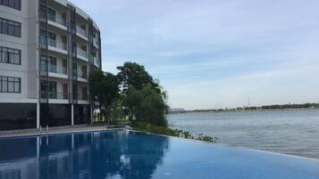 A modern building with a pool and a river view.