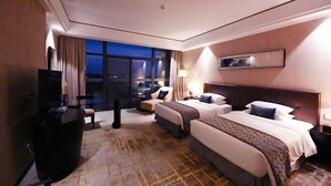 A hotel room with two beds, a desk, a chair, a TV, and a large window with a city view. - Jiuhua Chunshenhu Suzhou (Suzhou)