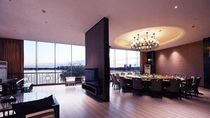A spacious room with a large round table, comfortable seating, and a view of the cityscape through large windows. - Rosedale Chunshenhu Resort Hotel Suzhou (Suzhou)