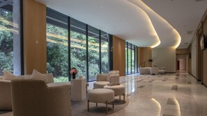 Een ruime lobby met grote ramen, comfortabele zitplaatsen en een modern design.