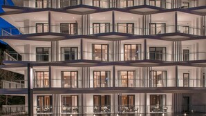 Een meerlaags hotel met een modern ontwerp, met balkons, grote ramen en een ruime lobby.