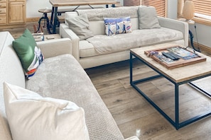 Relax in this inviting living space with a sofa, coffee table, and lamp.