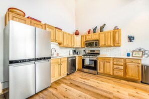 Enjoy cooking in this well-equipped kitchen with a refrigerator, dishwasher, microwave, oven, and sink.