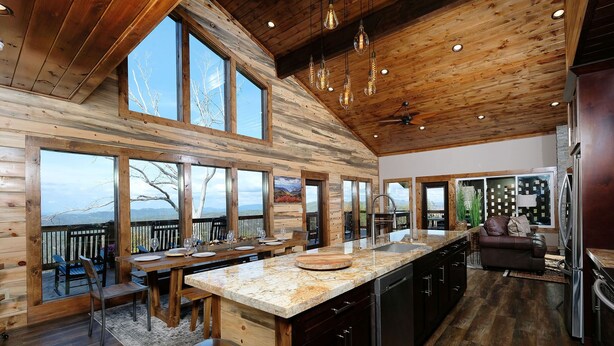 A spacious kitchen with a large island, wooden cabinetry, and a view of the mountains.