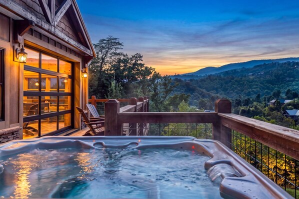 A hot tub on a deck with a view of a forested mountain range. - Moonlit Lodge - Hot Tub, Modern Vibes & Firepit (Sevierville)