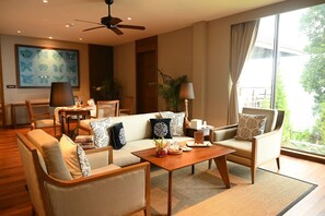 A modern living room with a sofa, chairs, a coffee table, and a painting on the wall. - Taj Chia Kutir, Resort & Spa (Kurseong)
