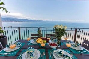 A table set for two with a view of the sea and mountains. - Stunning bay views beachfront 25th floor condo (Puerto Vallarta)