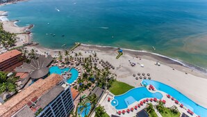 Un resort con una piscina grande, playa y vista al océano.