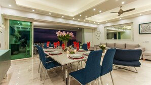 Un comedor moderno con una mesa larga, sillas azules y vistas al cielo nocturno.